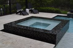 an outdoor hot tub with chairs around it