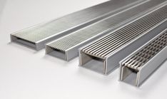 three different types of metal bars on a white surface, one is silver and the other is stainless steel