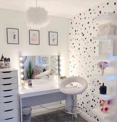 a room with a vanity, mirror and stools in the corner is decorated with polka dot wallpaper