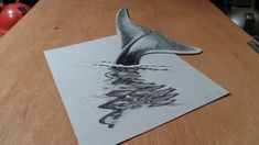 a drawing of a whale's tail is shown on top of a piece of paper