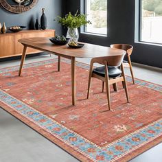 a dining room table with two chairs and a rug on the floor