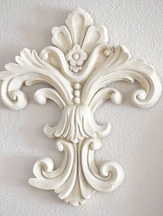 an ornate white wall hanging on the side of a building