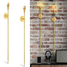 two gold candles are next to a brick wall and a radio is on the table