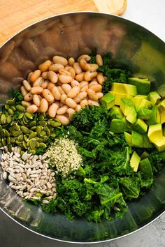 a metal bowl filled with vegetables and beans