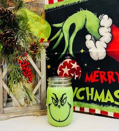 a green grin face jar sitting next to a christmas sign