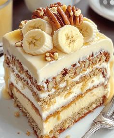 a piece of cake with bananas and pecans on top is sitting on a plate