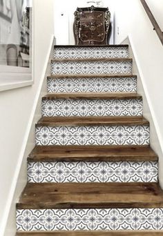 the stairs are decorated with blue and white tile designs, along with an antique suitcase