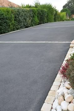 an empty parking lot with rocks and plants