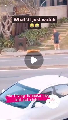 a white car driving down a street next to a person walking on the sidewalk with a dog