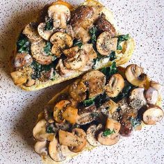 two slices of pizza with mushrooms and spinach on them sitting on a counter top