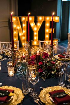 the table is set with candles, plates and place settings for an elegant dinner party