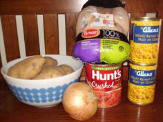 some food is sitting on a table next to an empty bowl and two cans of soup