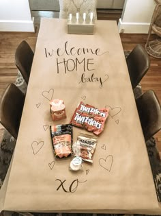 a welcome home sign on a table with candy and candies in front of it