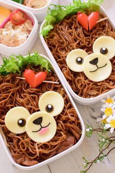 three bento boxes filled with noodles and topped with bear faces