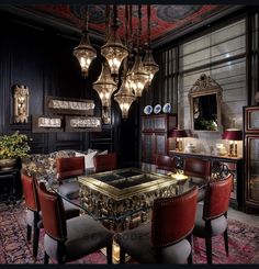 a fancy dining room with chandelier and red upholstered chairs around a glass table