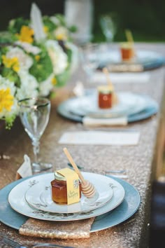 the table is set with plates and honeycombs on them, along with flowers