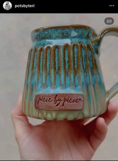 a hand holding a blue and brown coffee mug with writing on the inside of it