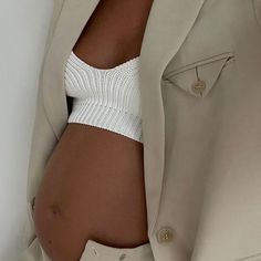 a close up of a person wearing a suit and white bra with buttons on it