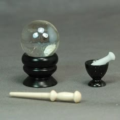 a glass ball sitting on top of a black stand next to a white toothbrush