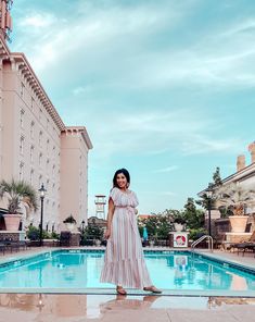 a woman standing in front of a swimming pool