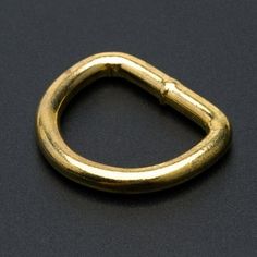 a gold colored metal ring on a black surface with a small hole in the middle