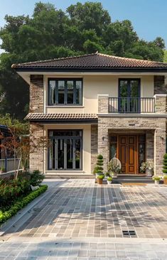 a large house with two story windows and lots of greenery on the front lawn