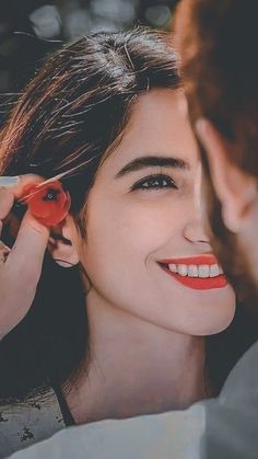 a woman is smiling as she gets her hair combed by a man with an orange tie