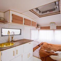 a bedroom with a bed, sink and window in the corner next to a counter