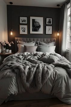 a large bed sitting next to a window in a room with pictures on the wall