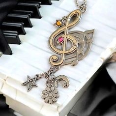 a musical key chain with a treble and star charms hanging from it's end