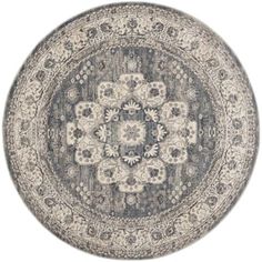 a round rug with an ornate design on the center and bottom, in grey tones