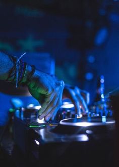 a dj mixing music on his turntable in the dark