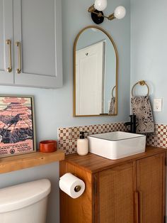 a bathroom with a sink, toilet and mirror in it's centerpieces