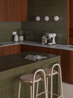 two stools sit in front of a counter top with an open book on it