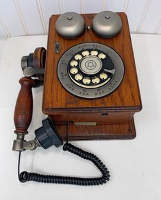 an old fashioned wooden phone with two dials