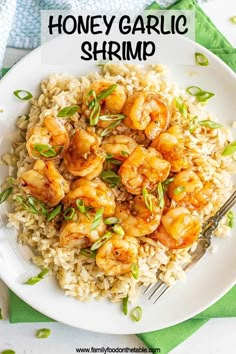 a white plate topped with rice covered in shrimp and garnished with scallions