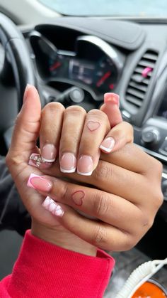 two hands holding each other while sitting in a car