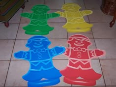 four plastic gingerbread men lined up on the floor