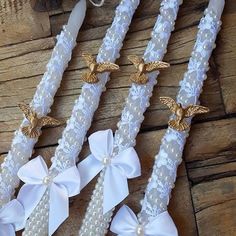 three white and gold wedding garters with pearls, bows and angel wings on them