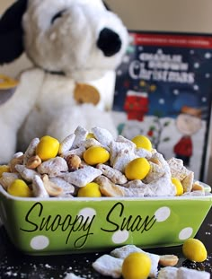 there is a bowl of puppy chow next to a stuffed dog and some books on the table