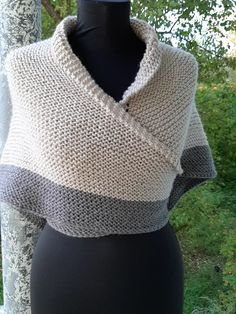 a knitted shawl on a mannequin with trees in the background