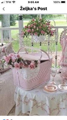 a pink and white basket sitting on top of a table next to a chair covered in flowers