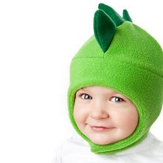 a young child wearing a green hat and scarf