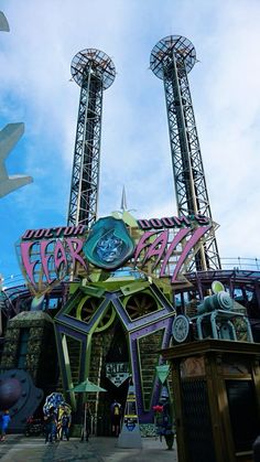 the entrance to an amusement park with roller coasters