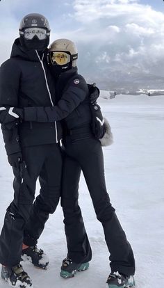 two snowboarders hugging each other in the snow