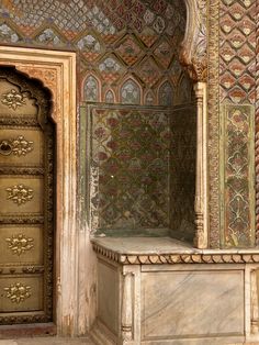 an ornately decorated room with two doors and a marble bench in the center,