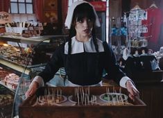 a woman standing in front of a counter filled with food