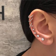 a woman's ear is shown with three different types of piercings on it