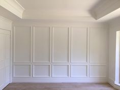 an empty room with white paneling and wood flooring on the walls is seen in this image