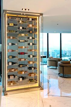 a large wine rack in the middle of a living room with glass walls and floor to ceiling windows